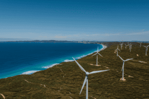 Gentle breeze wind turbines on coastal hillside with ocean views, renewable energy renewable energy source, sustainable wind farm, green energy, ocean coastline, wind power, environmental conservation, renewable energy technology.